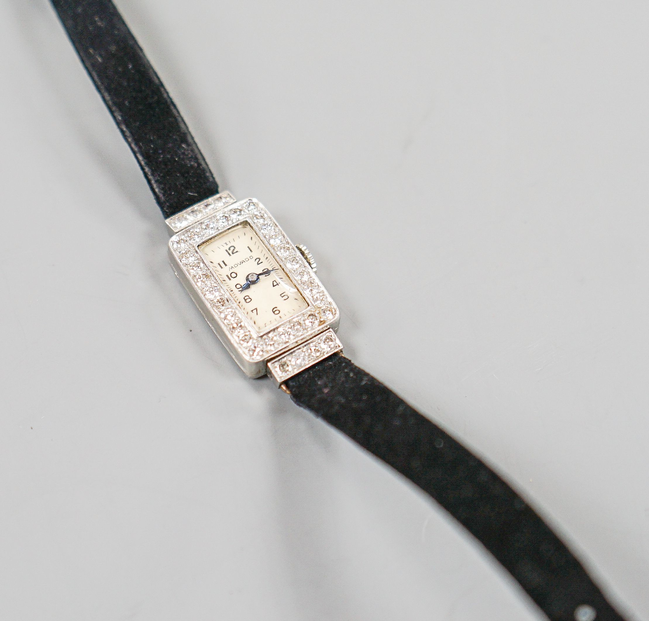 A lady's 950 white meta l(platinum?) and diamond set Movado manual wind wrist watch, on a later fabric strap, gross weight 15.2 grams.